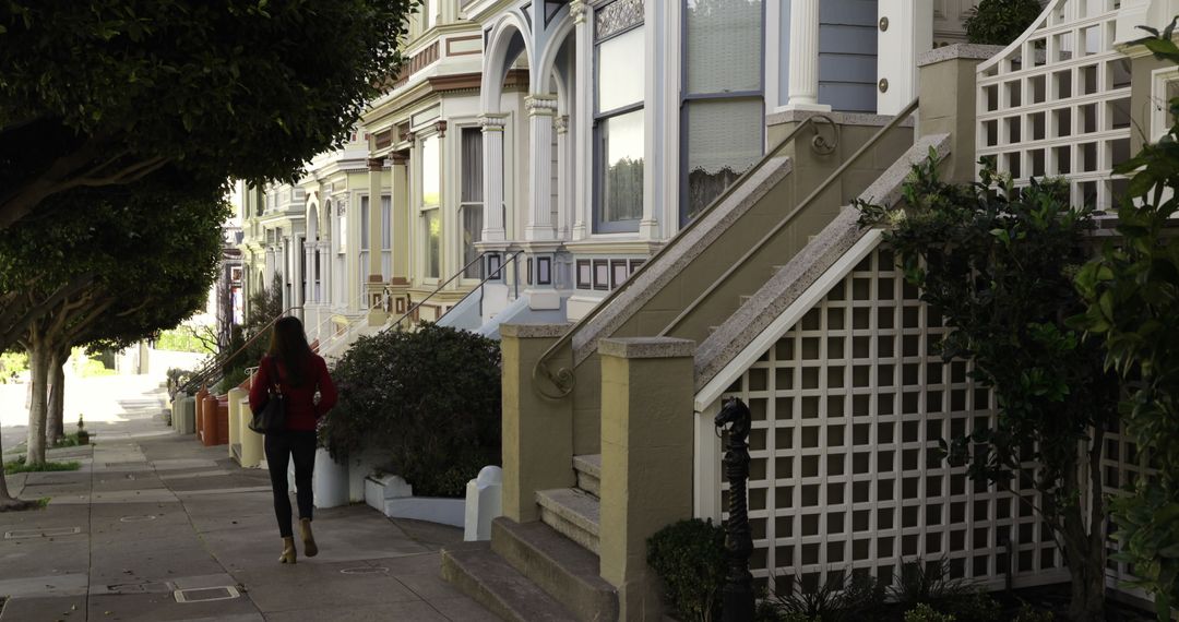 Woman walking past Victorian houses on tree-lined street - Free Images, Stock Photos and Pictures on Pikwizard.com