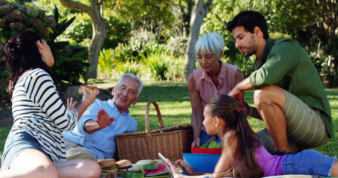 Happy Multigenerational Family Enjoying Picnic in Sunlit Park - Free Images, Stock Photos and Pictures on Pikwizard.com