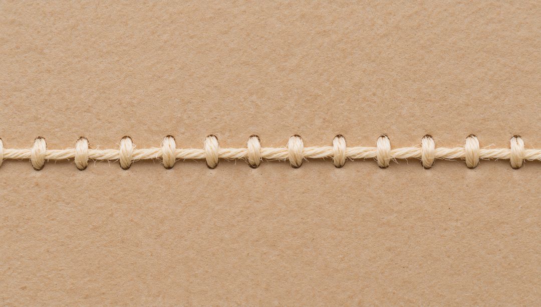 Beige Twine Running Across Kraft Paper Stitching Seam for Packaging Crafting and Stationery