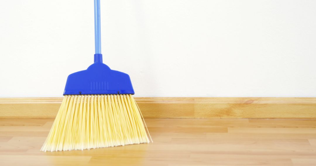 Simple Blue Broom Against White Wall on Wooden Floor - Free Images, Stock Photos and Pictures on Pikwizard.com