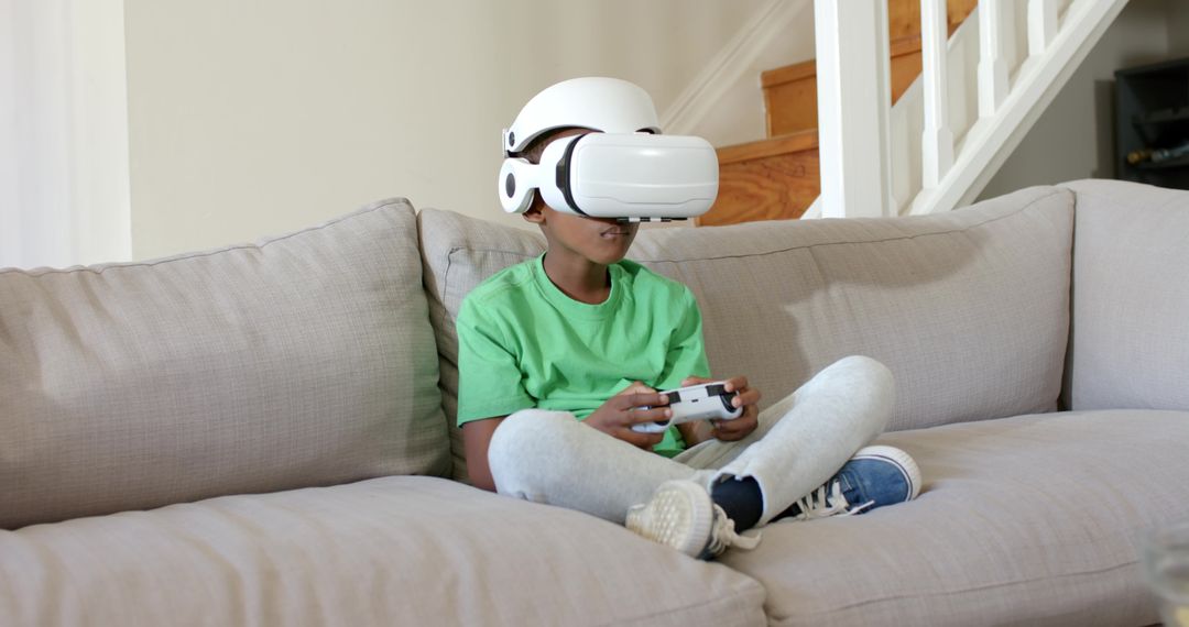 Young African American Boy Playing Virtual Reality Game on Couch at Home with Controller