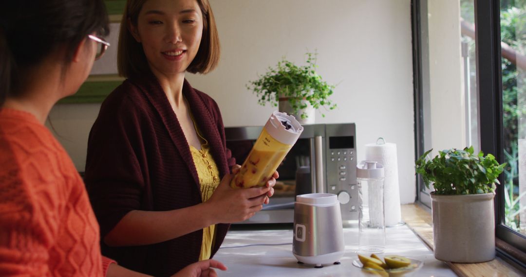 Two Women Preparing Smoothie in Modern Kitchen - Free Images, Stock Photos and Pictures on Pikwizard.com