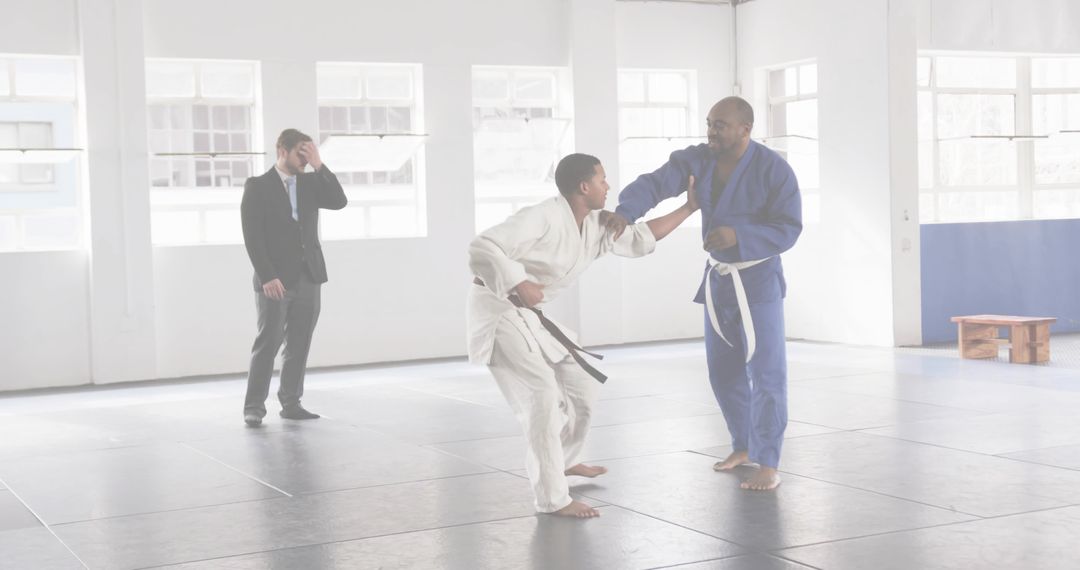 Instructor Coaching Student Gripping Collar in Gi on Dojo Mats with Observing Coach
