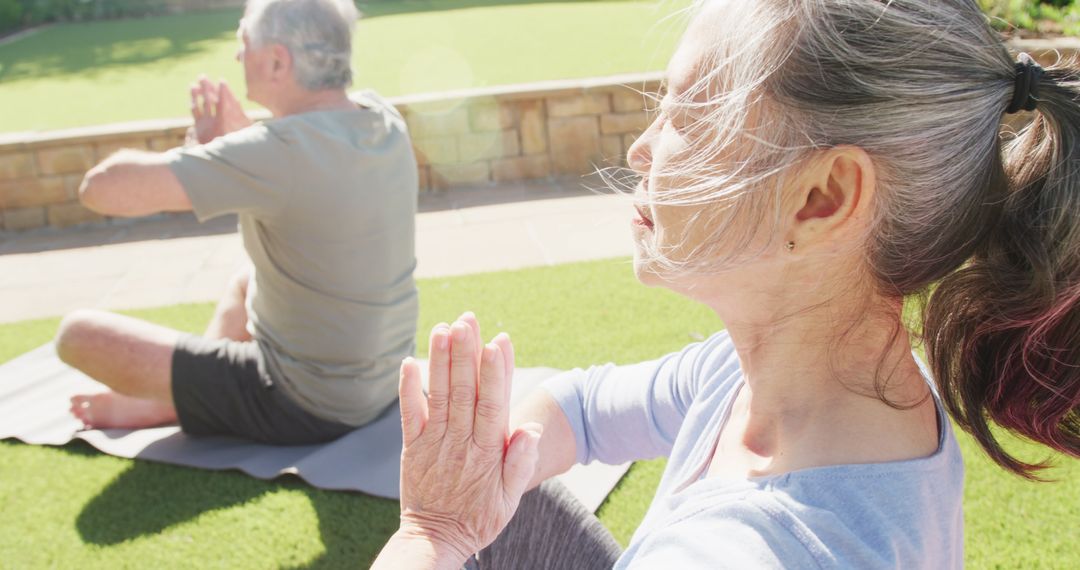 Senior couple meditating on yoga mats in garden - Free Images, Stock Photos and Pictures on Pikwizard.com