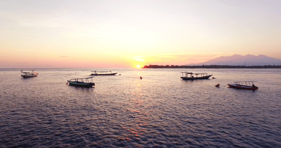 Boats Sailing in Open Sea During Beautiful Transparent Sunset