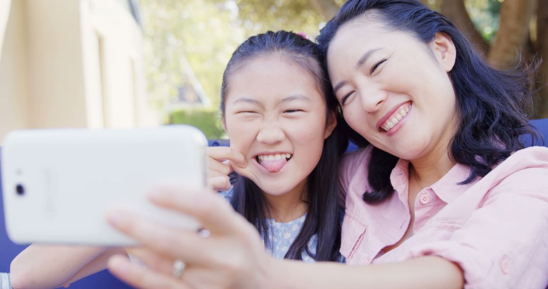 Mother and Daughter Taking Selfie Outdoors with Smiles - Free Images, Stock Photos and Pictures on Pikwizard.com