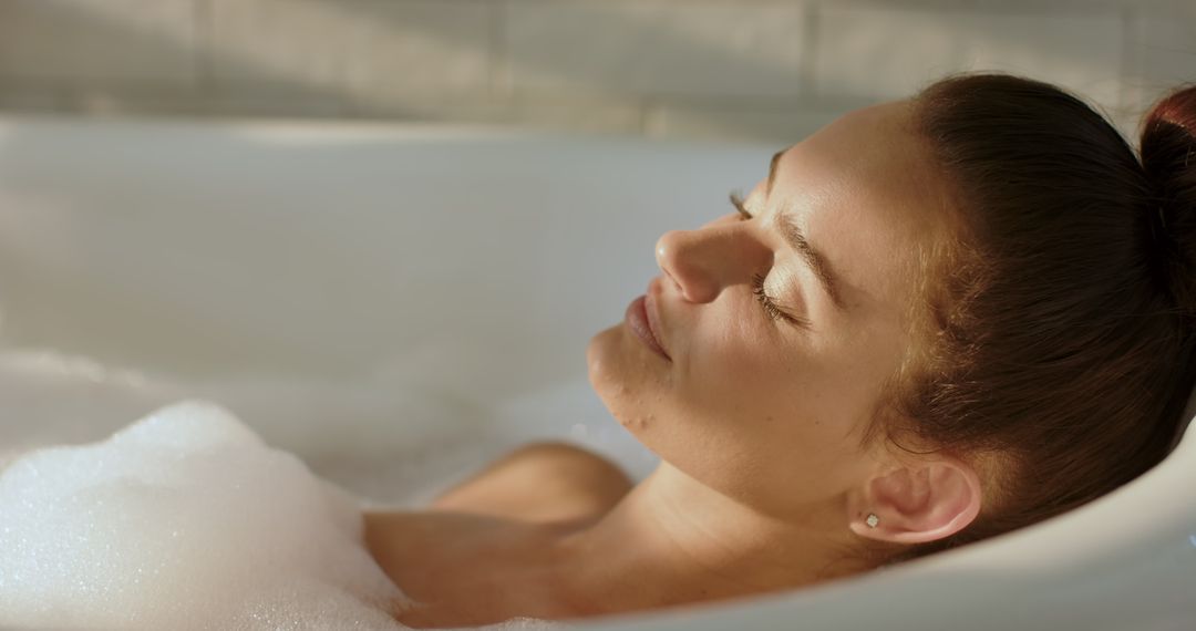 Woman Relaxing in Bathtub with Bubbles in Ambient Light