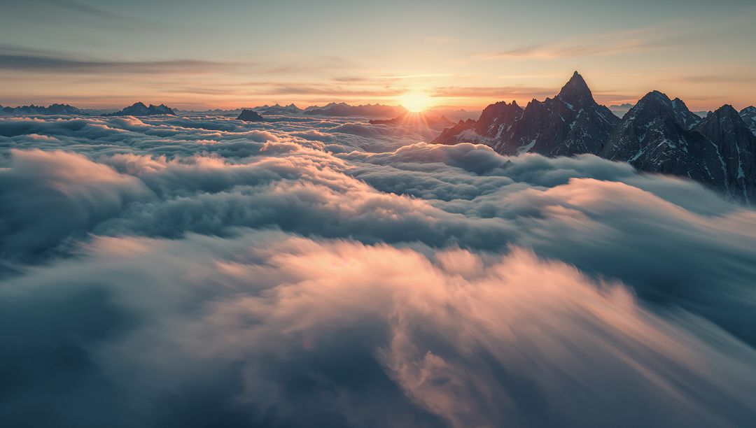 Sunrise Over Mountain Peaks Amidst Sea of Clouds