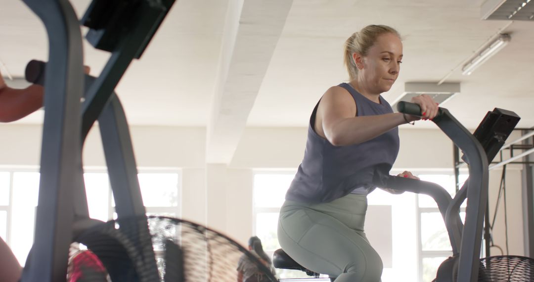 Woman Exercising on Elliptical Machine in Gym - Free Images, Stock Photos and Pictures on Pikwizard.com