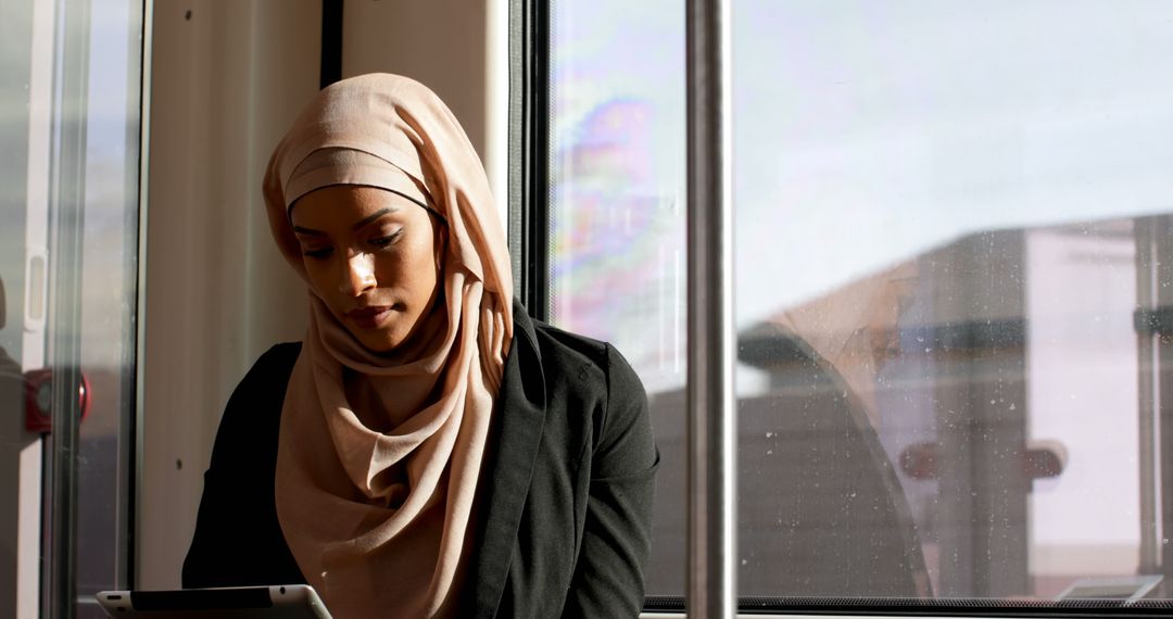 Young Muslim Woman Traveling by Train and Using Tablet - Free Images, Stock Photos and Pictures on Pikwizard.com