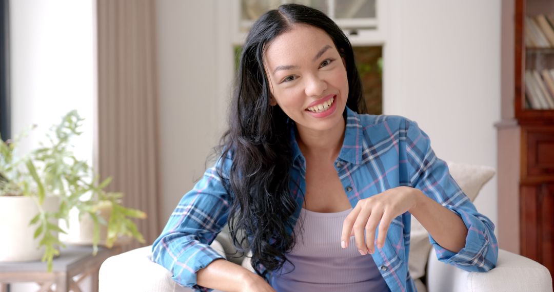 Smiling Woman Relaxing on Couch During Video Call at Home