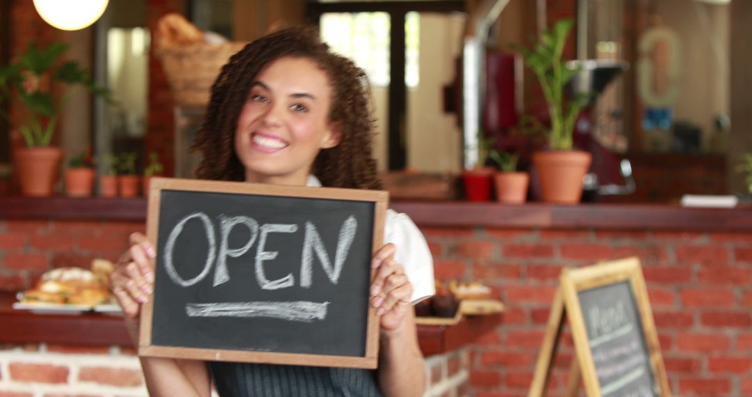 Smiling Female Cafe Owner Holding Open Sign in Rustic Coffee Shop - Free Images, Stock Photos and Pictures on Pikwizard.com