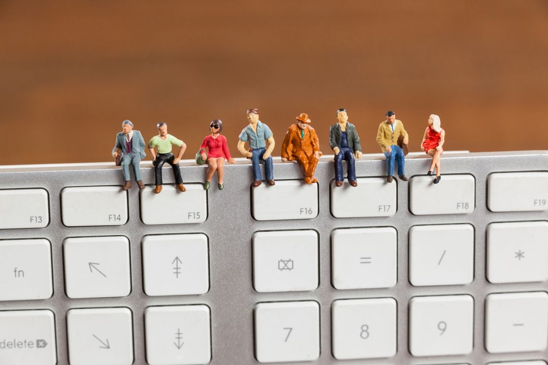 Miniature People on Keyboard Representing Technology and Society