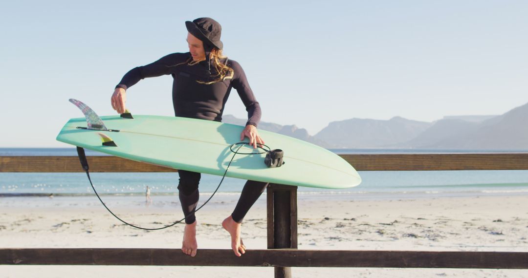 Female Surfer Prepares Surfboard by Beach - Free Images, Stock Photos and Pictures on Pikwizard.com