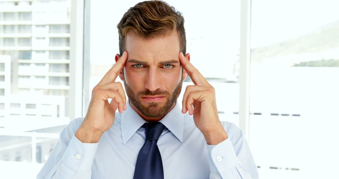 Confident Businessman Focusing in Modern Office Environment - Free Images, Stock Photos and Pictures on Pikwizard.com