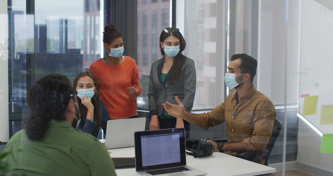 Team Collaborating in Office While Wearing Face Masks During Pandemic - Free Images, Stock Photos and Pictures on Pikwizard.com