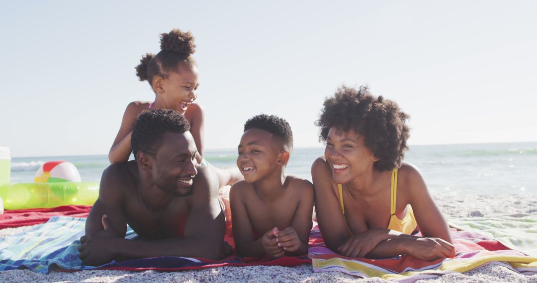 Portrait of smiling african american family lying on sunny beach - Free Images, Stock Photos and Pictures on Pikwizard.com