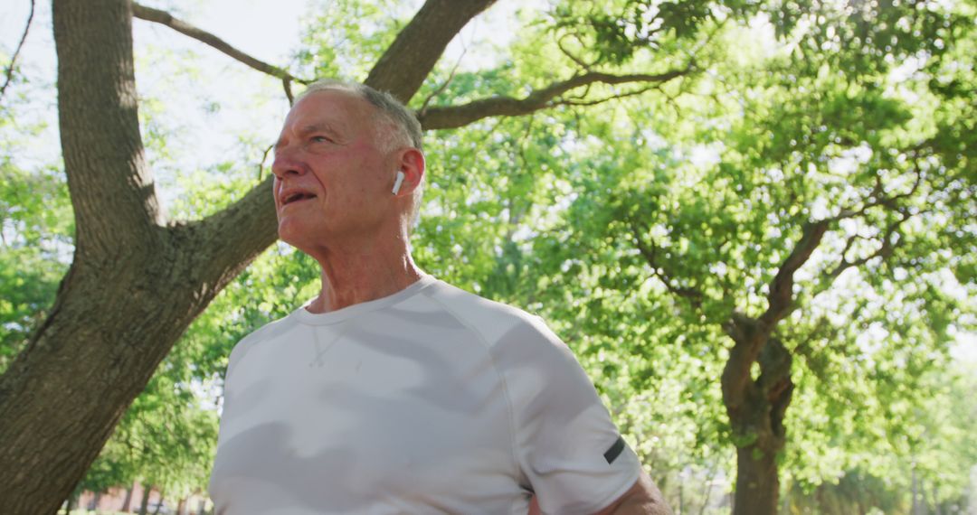 Mature Man Exercising in Park with Wireless Earbuds - Free Images, Stock Photos and Pictures on Pikwizard.com