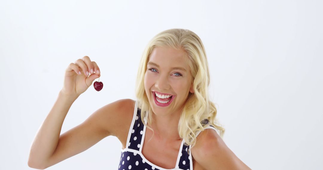 Cheerful Woman Holding Heart-Shaped Object, Wearing Polka Dot Top - Free Images, Stock Photos and Pictures on Pikwizard.com