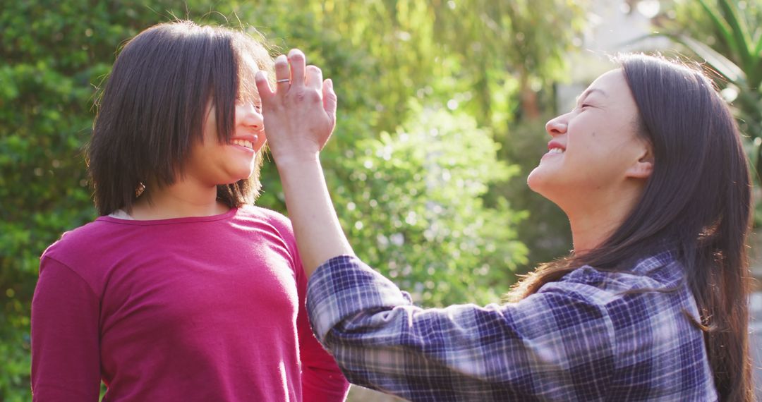 Image of happy asian mother and daughter having fun in garden - Free Images, Stock Photos and Pictures on Pikwizard.com