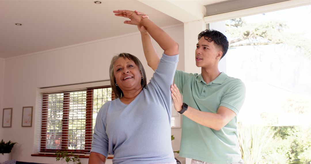Young Physiotherapist Assisting Senior Woman with Arm Exercises