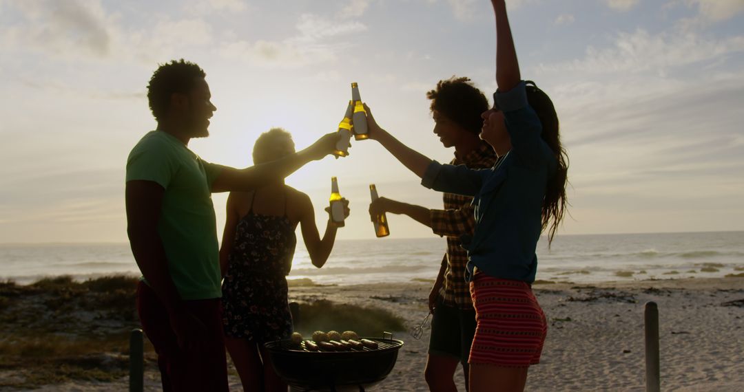 Friends Cheerfully Toasting Beers at Beach Barbecue During Sunset - Free Images, Stock Photos and Pictures on Pikwizard.com