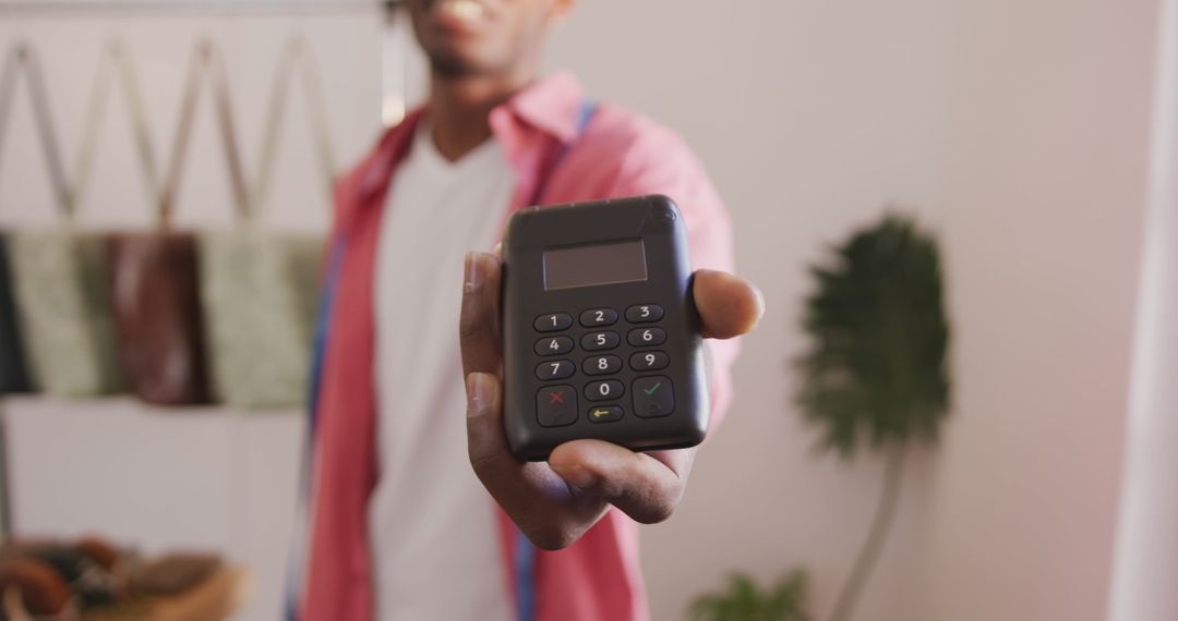 Small Business Owner Showing Card Reader in Workshop