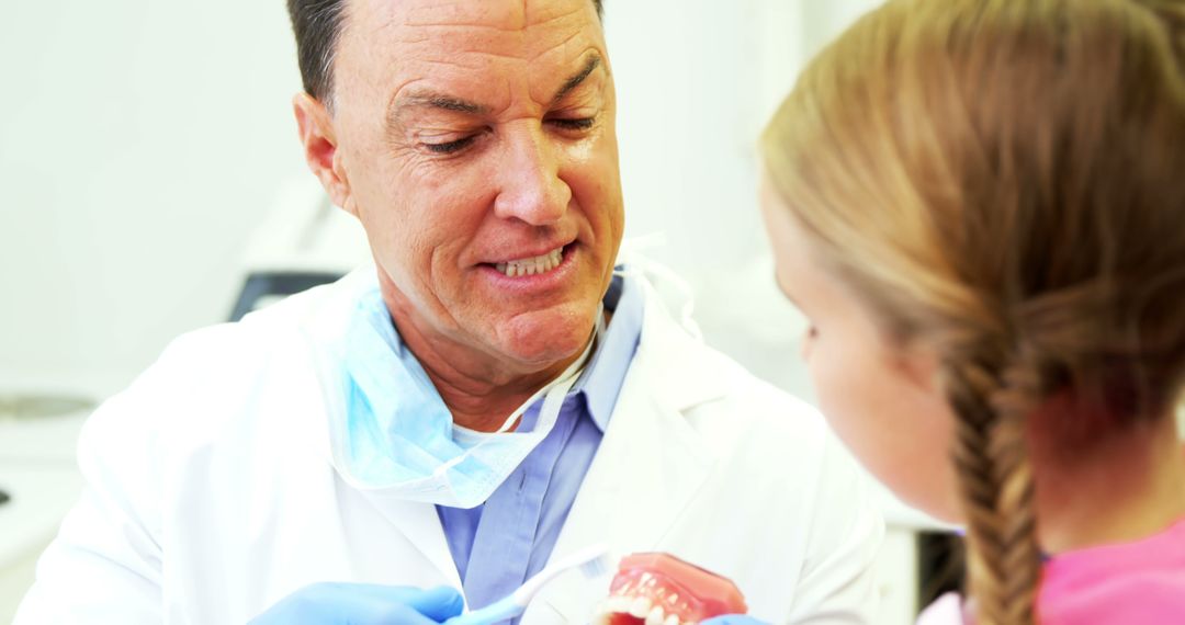 Dentist Explaining Dental Hygiene to Girl in Office - Free Images, Stock Photos and Pictures on Pikwizard.com