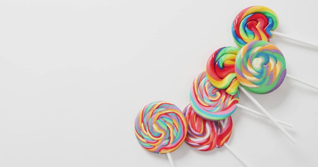 Vibrant Array of Multi-colored Swirled Lollipops on White Background - Free Images, Stock Photos and Pictures on Pikwizard.com