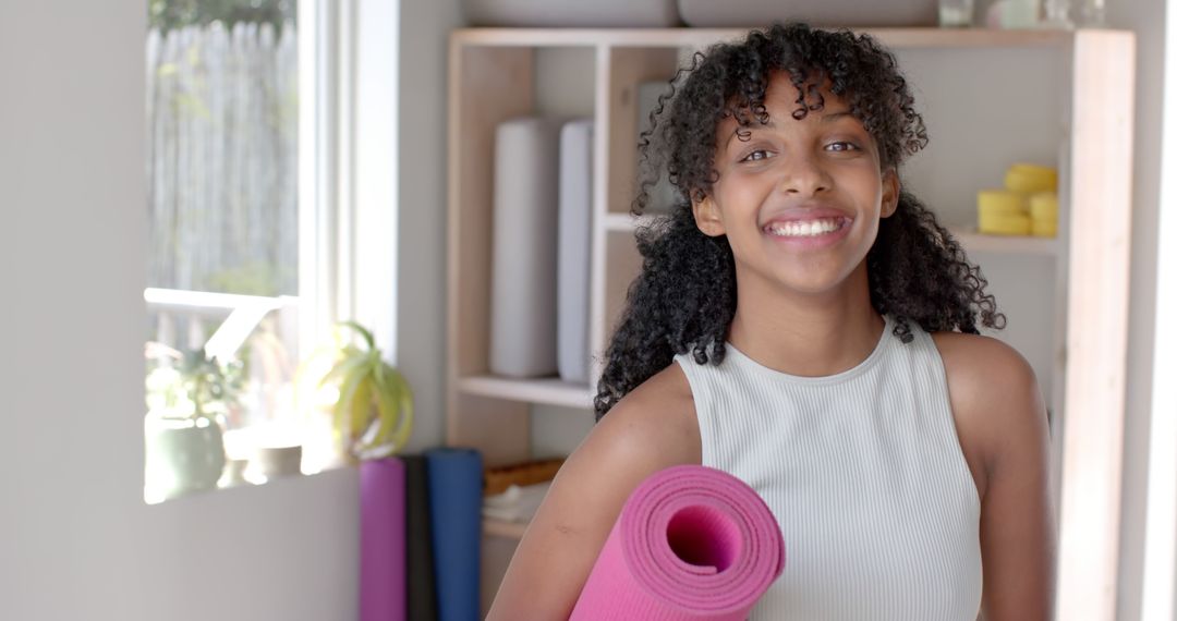 Young Woman Holding Yoga Mat in Bright Studio - Free Images, Stock Photos and Pictures on Pikwizard.com