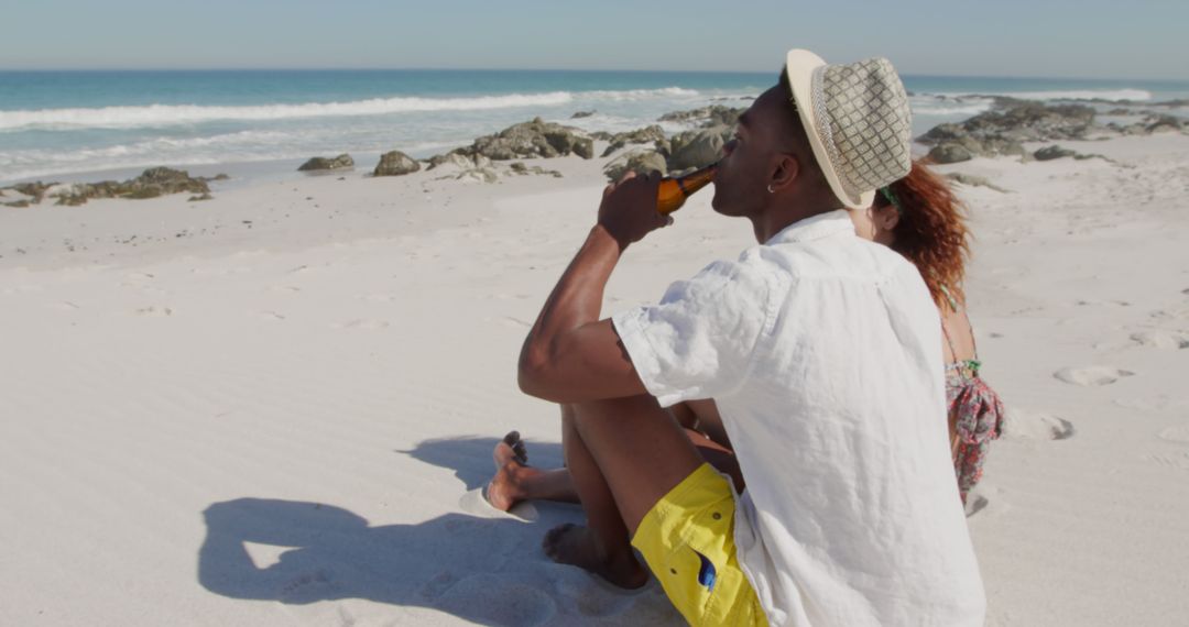 Young Couple Relaxing on Beach with Beer on Sunny Day - Free Images, Stock Photos and Pictures on Pikwizard.com