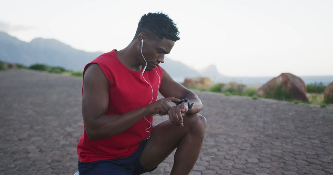 Fit Man Checking Smartwatch While Kneeling Outdoors - Free Images, Stock Photos and Pictures on Pikwizard.com