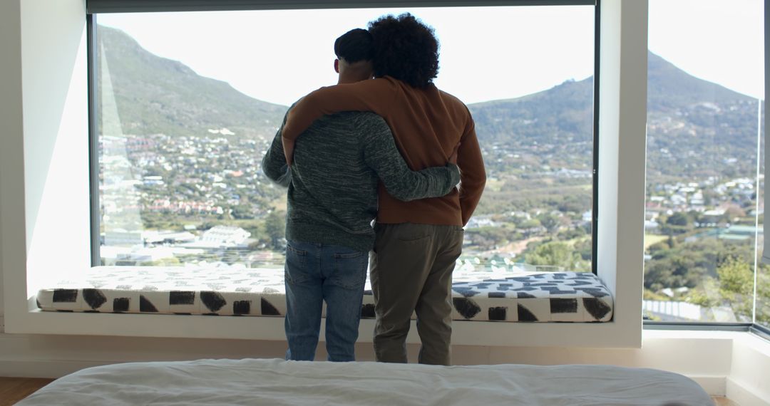 Father and Son Embracing While Enjoying Scenic View from Modern Home