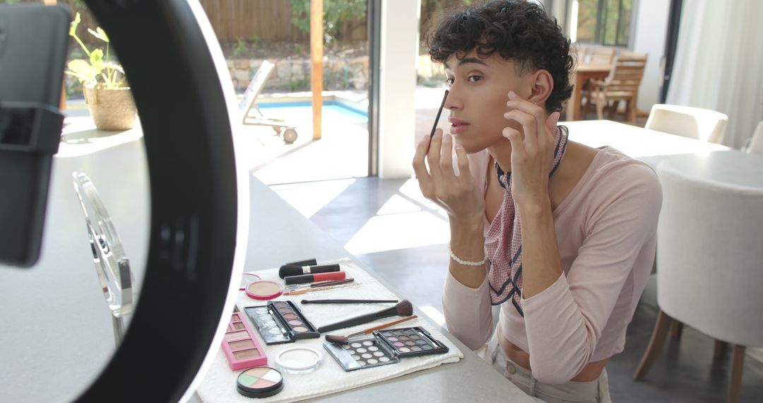 Man Applying Makeup Using Ring Light in Kitchen