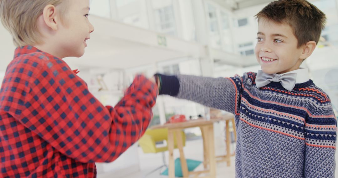 Two Boys Sharing Playful Fist Bump Indoors