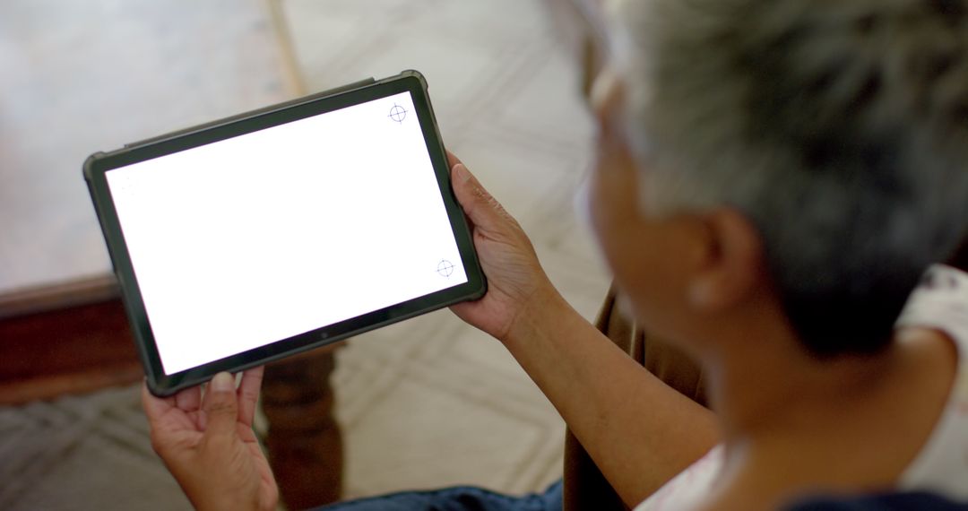 Senior Woman Using Tablet with Blank Screen at Home