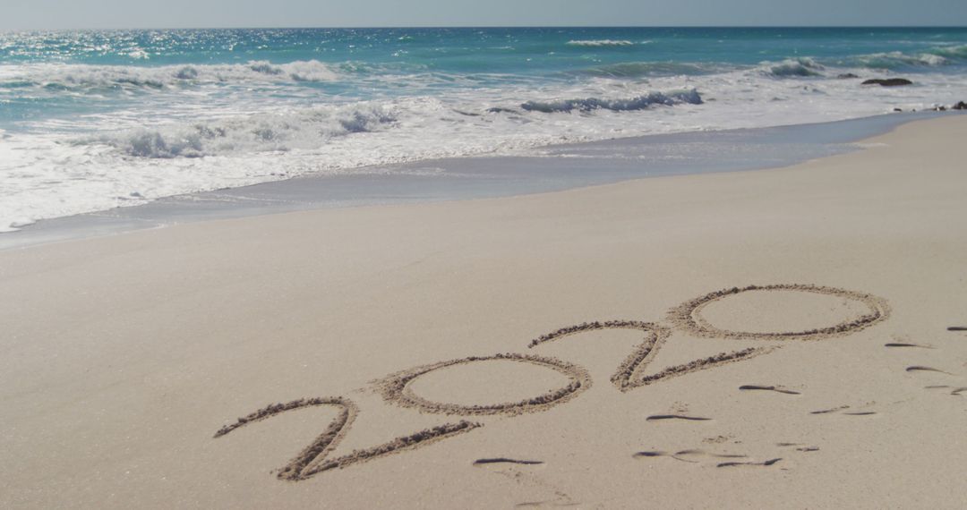 2020 Written on Sandy Beach with Ocean Waves in Background - Free Images, Stock Photos and Pictures on Pikwizard.com