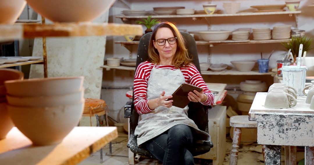 Female Pottery Artisan Relaxing in Studio with Digital Tablet - Free Images, Stock Photos and Pictures on Pikwizard.com