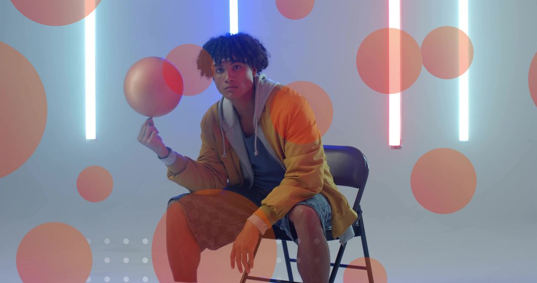 Contemporary Man Balancing Sphere in Neon-Lit Studio