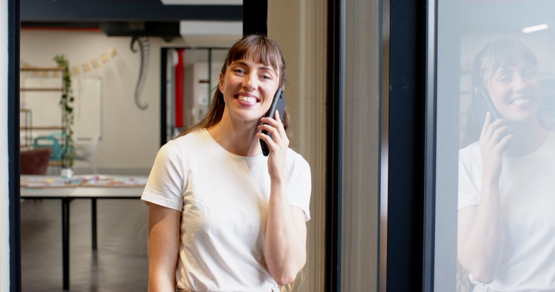 Businesswoman Smiling On Phone in Modern Office Environment
