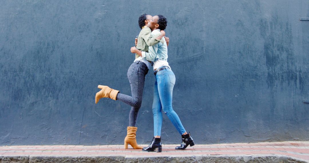 Overjoyed Twin Sisters Interacting on Urban Street