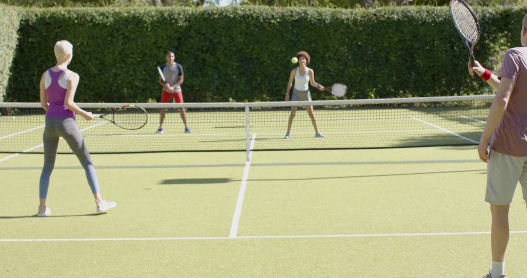 Group of Diverse Adults Playing Doubles Tennis Outside - Free Images, Stock Photos and Pictures on Pikwizard.com