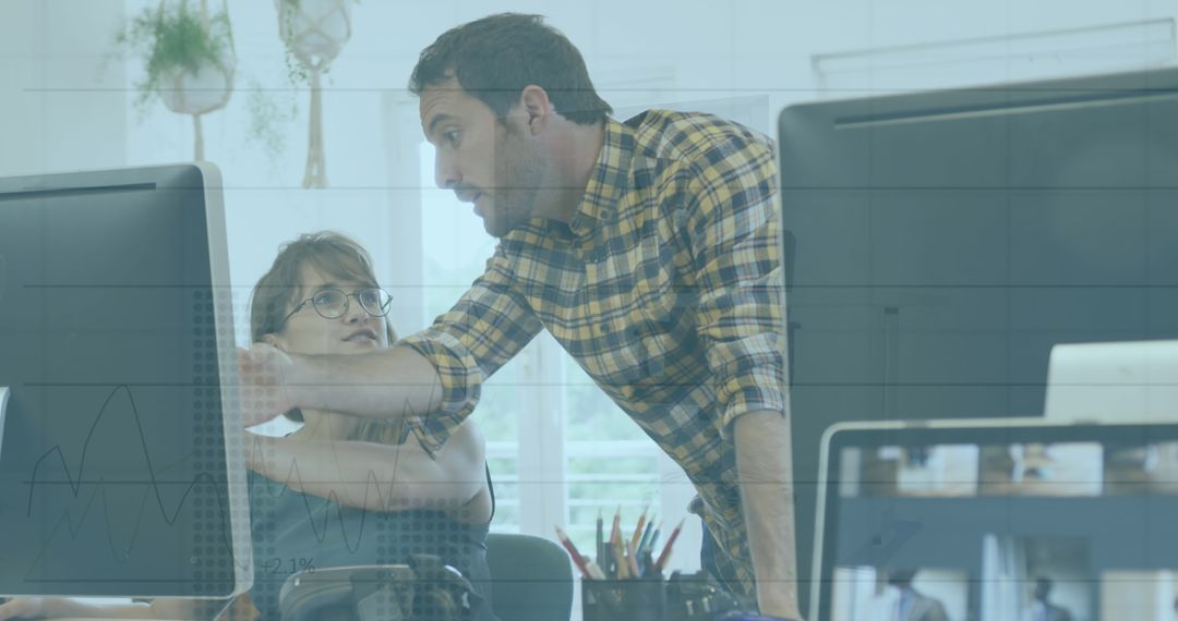 Colleagues Analyzing Data on Computer Monitors in Office