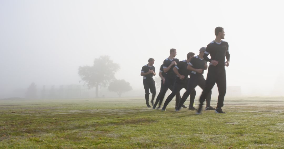 Male Athletes in Synced Run through Foggy Field