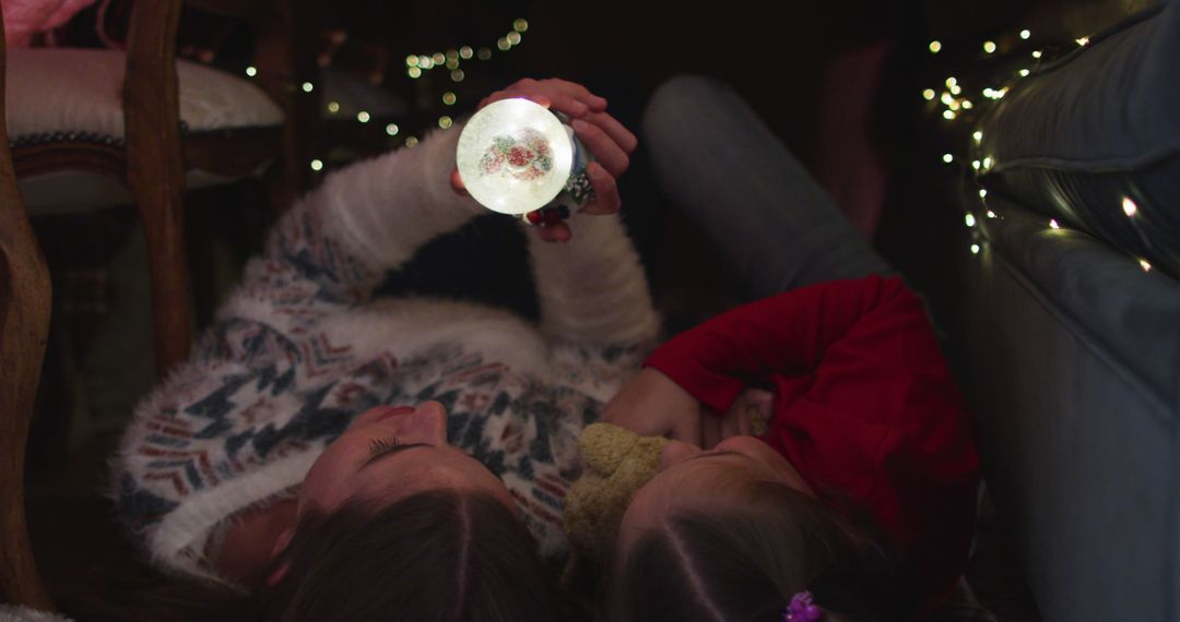 Mother and Daughter Having Cozy Moments with Christmas Lights - Free Images, Stock Photos and Pictures on Pikwizard.com