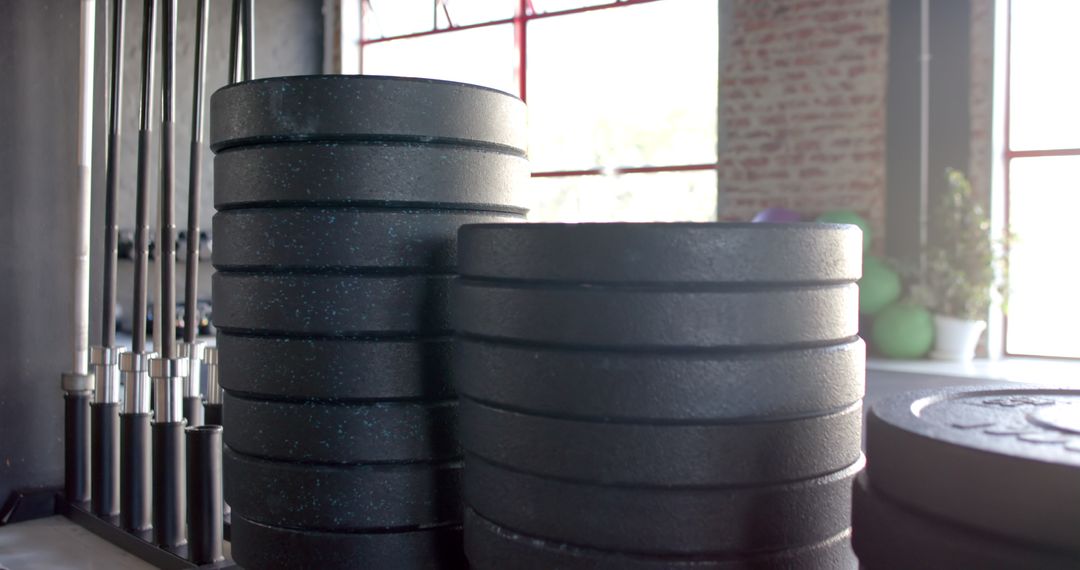 Stacked Black Weight Plates in Sunlit Gym Setting