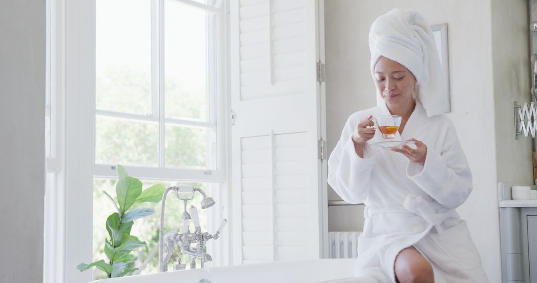 Relaxed Woman Enjoying Tea in Bathroom After Bath - Free Images, Stock Photos and Pictures on Pikwizard.com