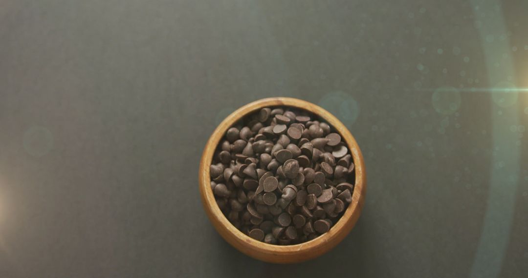 Chocolate Chips Bowl on Textured Surface with Creative Lighting