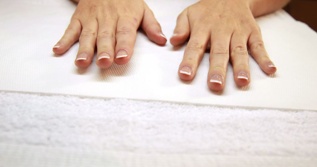 Hands Resting on White Towel with French Manicure - Free Images, Stock Photos and Pictures on Pikwizard.com