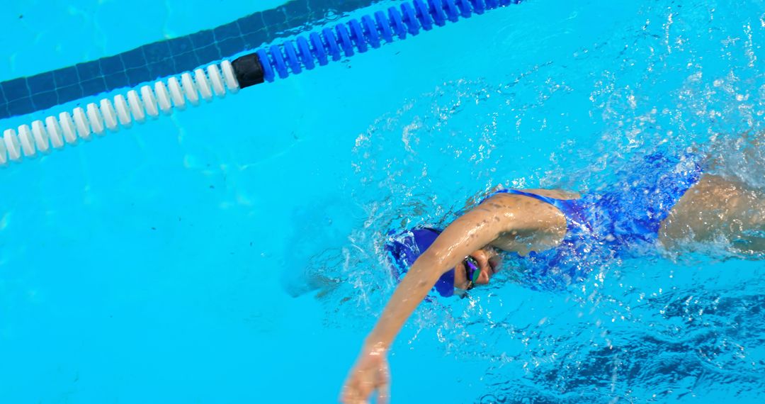 Swimmer doing freestyle swimming in a pool, wearing blue equipment - Free Images, Stock Photos and Pictures on Pikwizard.com